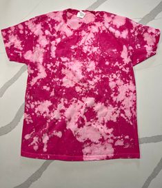 a pink and white tie - dyed t - shirt sitting on top of a table