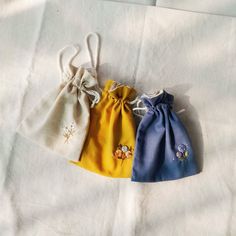 three small draws are lined up on a white sheet with blue and yellow linens