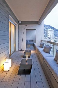 an outdoor living area with couches and candles on the floor next to each other