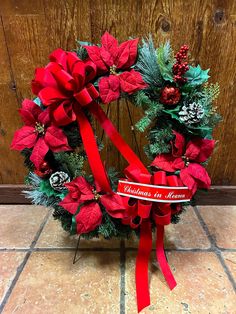 a christmas wreath with poinsettis and pine cones