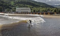 a man riding a wave on top of a surfboard in the middle of water