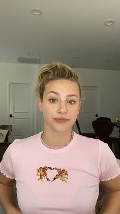 a woman in a pink shirt is taking a selfie