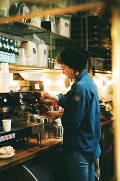 a woman standing in front of a counter preparing food