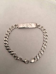 a silver bracelet with the word f & n engraved on it's clasps