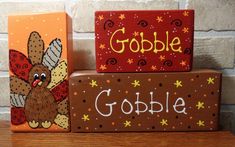 three wooden blocks with painted turkeys and the word gobble on them