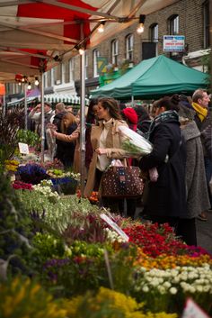 people shopping at an outdoor flower market