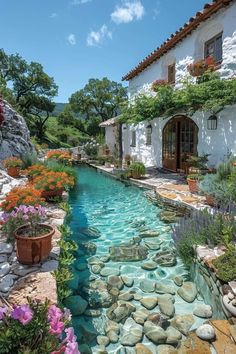 an outdoor pool with rocks and flowers surrounding it