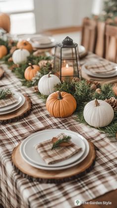 the table is set with pumpkins, pine cones and plaid napkins on it