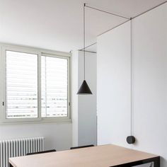 an empty room with a wooden table and black chairs