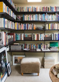 a bookshelf filled with lots of books in a living room