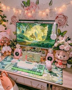 there is a computer on the desk with stuffed animals and flowers in front of it