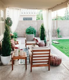 an outdoor living area with chairs, tables and potted plants