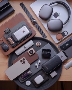 an assortment of electronics and accessories laid out on top of a wooden table next to each other