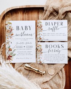 the wedding stationery is laid out on a wooden tray