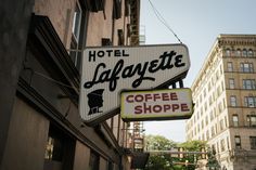 a hotel lafayette coffee shop sign hanging from the side of a building in new york city