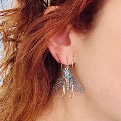 Mosquito drop earrings
 	1.25″ x 1.5″
 	Stainless steel with brass accents
 	Oil-Slick Blue heat patina
 	Art Deco style

 	Layered design - THE WINGS MOVE! Silver Electroformed Earrings, Cicada Art, Patina Art, Elizabeth Jewelry, Oil Slick, Jewelry Tags, Layered Design, Brass Accents, The Wings