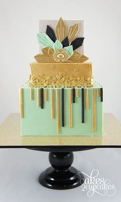 a three tiered cake with gold and black decorations on the top, sitting on a pedestal