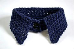 a crocheted blue scarf with a black button on it