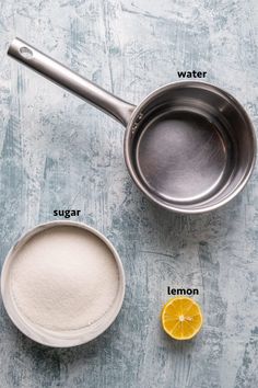 ingredients to make lemonade on a blue background with the words, water, sugar and lemon