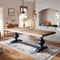 a dining room table in the middle of a kitchen