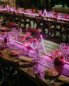 a long table is set up with pink flowers and place settings for an elegant dinner