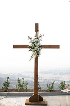 a wooden cross with flowers on top of it