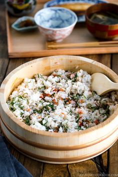 a wooden bowl filled with rice and vegetables