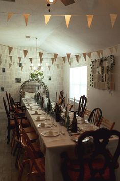 a long dining table is set up with place settings for six people to sit at