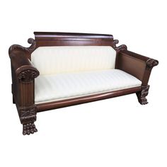 a wooden couch with white cushions on it