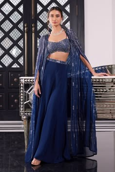 Electric blue cape with bugle beads, sequin and crystal embroidery in a striped pattern. Comes with strappy bralette and sharara.
Component: 3
Pattern: Embroidery
Type Of Work: Bugle Beads, Sequin and Crystals
Neckline: Sweetheart
Sleeve Type: Cape Sleeves
Fabric: Tussar and Organza
Color: Blue
Other Details: 
Open front cape with asymmetrical hem
Waistband embroidery
Shoulder straps
Closure: Sharara: Side zip
Occasion: Sangeet - Aza Fashions Cape Jacket Outfit Indian, Cocktail Indian Dress, Blue Mehendi Outfit, Indian Cape Outfits, Shrug Style Dresses Indian, Blue Traditional Outfit, Blue Suits Women Indian, Sharara With Cape, Sangeet Outfits For Women