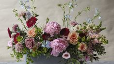 a vase filled with lots of flowers on top of a table