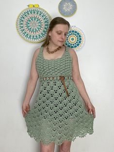 a woman is standing in front of some crocheted doily and circular artwork