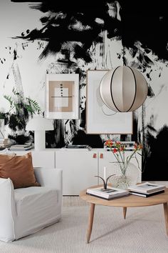 a living room with two white couches and a coffee table in front of a painting on the wall