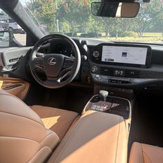 the interior of a car with tan leather seats and electronic display on the dash board