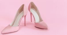 a pair of pink high heeled shoes on a pink background