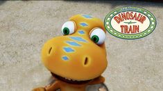 a cartoon dinosaur with blue stripes on it's face and eyes, standing in front of a sign that says dinosaur train