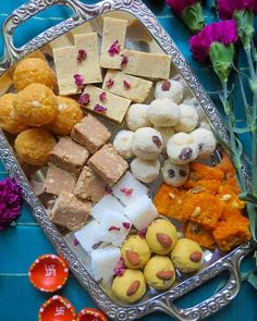 a silver tray filled with different types of food on top of a blue table cloth