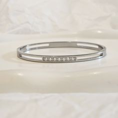 Our Diamond Station Bangle is the perfect stacking bangle. It features round set CZ crystals for a minimalist look. You can wear this minimalist bangle alone or stacked. This item is made from 316L stainless steel which is of the highest quality and waterproof as well as nickel free, lead free and cadmium free. We make our jewellery in small batches to reduce wastage. Our jewellery is designed with the modern Woman in mind, elegant, unique pieces with a classic touch. Our jewellery is great for Bangle Stacking, Minimalist Bangle, Valentines Sale, Bracelet Minimalist, Stacked Bangles, Stackable Bracelets, Minimalist Bracelet, Cuff Bangles, Silver Diamonds