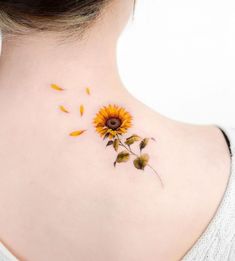 a sunflower tattoo on the back of a woman's neck