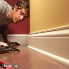 a man kneeling down on the floor with a pair of scissors in front of him