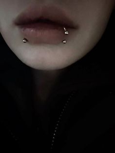 a woman with piercings on her nose in the dark