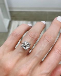 a woman's hand with a diamond ring on it