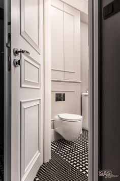 an open door leading to a bathroom with black and white checkered tile flooring