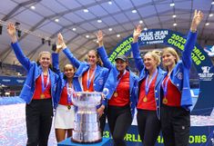 the women's tennis team is holding up their trophy