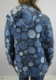 a woman wearing a denim jacket with blue circles on the back and white dots on the front