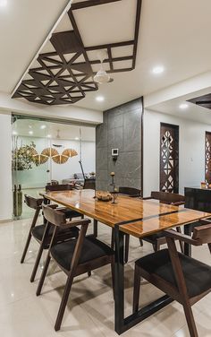 a dining room table and chairs in front of a glass wall