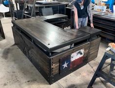 a man standing next to a table with an american flag painted on it in a shop