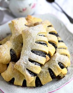 several pastries on a plate with powdered sugar