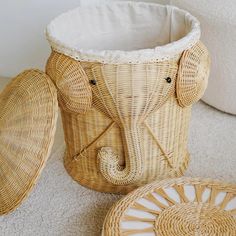 an elephant shaped basket sitting on top of a floor next to two plates and a bowl