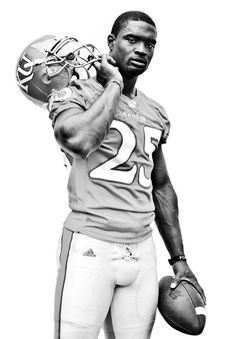 a black and white photo of a football player holding a ball in his right hand